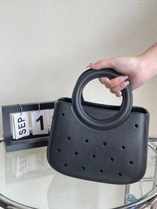 Détail du sac de plage en EVA noir avec poignée circulaire et texture perforée