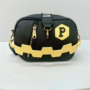 Detailed view of a black crossbody bag with yellow letter P patch and zigzag strap.