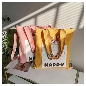 Detail of canvas tote bags with Corgi prints and functional front pockets in soft colors