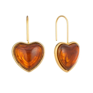 Gros plan sur des boucles d'oreilles cœur en résine ambre avec bordure dorée