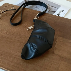 Détail du sac croissant noir avec coutures segmentées et fermeture éclair argentée