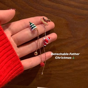 Festive Christmas earrings featuring Santa, tree, and sleigh on a wooden background