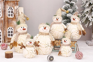 Close-up of plush snowman dolls with gold branch patterns and festive hats in a group set