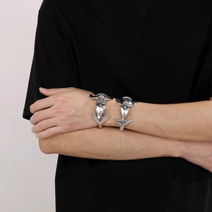 Gros plan de bracelets dauphins argentés sertis de brillants portés au poignet style hip-hop