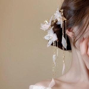 Gros plan détaillé sur une pince à cheveux fleurie en tissu avec perles et franges dorées