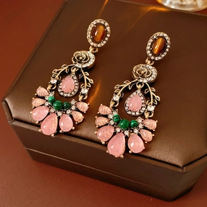 Detail of vintage flower earrings with colorful gems on a brown leather jewelry box