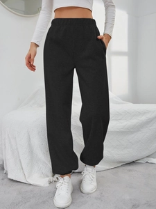 Dettaglio dei pantaloni sportivi neri con vita elastica e tasche laterali