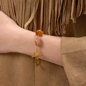 Retro stainless steel bracelet with amber resin beads and OT clasp on a suede background