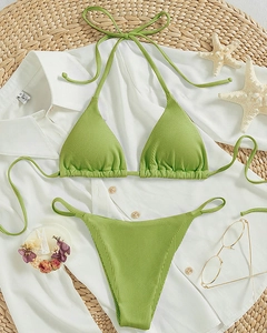 Flat lay of green ribbed halter bikini set with starfish and summer vacation props