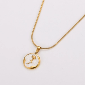 Detail view of round gold pendant with white shell inlay and rose on snake chain