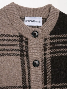 Close-up of brown plaid knitted cardigan with round neck and black round buttons