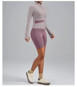 Detail of morandi purple high-neck yoga jacket and high-waist biker shorts set