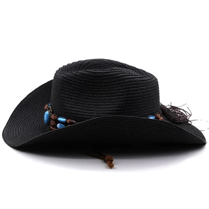 Close-up of black straw cowboy hat with ethnic beaded band and woven tassel detail