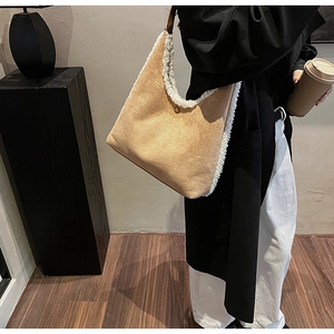 Detailed view of camel faux suede shoulder bag with white faux shearling trim on a model