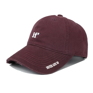 Detail of burgundy baseball cap with embroidered 'if' and 'NEVER GIVE UP' text on brim