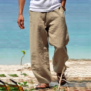 Detail view of khaki cotton linen casual straight leg pants for men on beach background