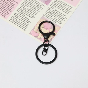 Matte black metal lobster clasp and key ring set shown on a decorative aesthetic background