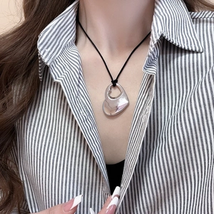 Close-up of a silver hollow double heart pendant on a black cord necklace for women