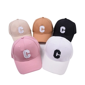 Flat lay view of various baseball caps with embroidered C letter in multiple colors
