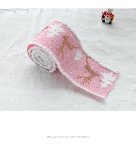 Pink Christmas ribbon with white reindeer and tree patterns and fuzzy edges