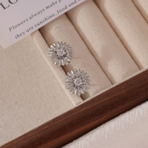 Silver sunflower stud earrings with crystal center displayed in a velvet jewelry box