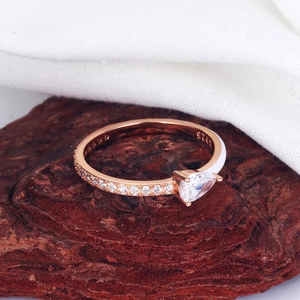 Macro shot of S925 silver ring featuring pear-shaped zircon and white enamel on wood