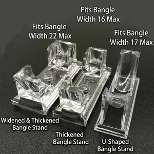 Three clear acrylic bracelet display stands for various jewelry sizes on a black surface