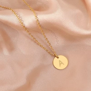 Gold 18k plated stainless steel necklace with letter A pendant on pink silk background