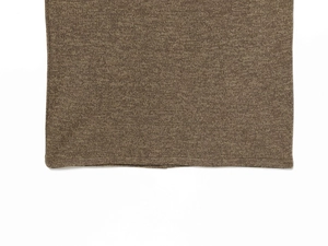 Detailed close-up of tan knit fabric texture and high-quality hem finishing