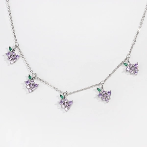 Detail of silver chain necklace with five purple zircon grape charms on white backdrop