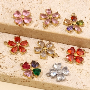 Detailed group shot of multi-colored zircon flower charms on a beige stone display