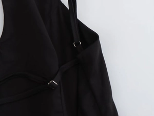 Détail de la robe noire avec fines bretelles réglables et anneau de connexion en métal