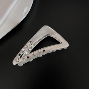 Detail of silver triangular hair claw with inset rhinestones and black heart motifs