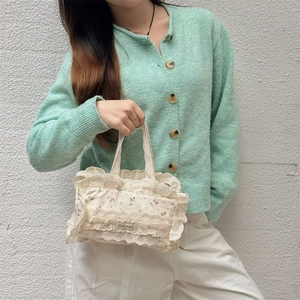 Détails d'un sac cabas en toile beige à fleurs avec bordure en dentelle délicate