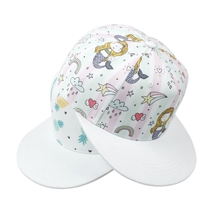 Detail of two kids' snapback hats with colorful rainbow and mermaid prints on white cotton