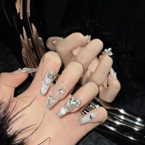 Handmade nude press-on nails with silver glitter gradient and 3D butterfly rhinestones