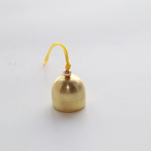 Close-up of a 2cm golden metal Christmas bell with a yellow hanging rope and gold bead