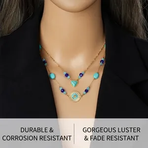 Close-up of double-layered gold necklace with turquoise heart and sun medallion on a model