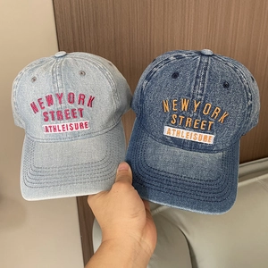 Detail of washed denim baseball caps in light and dark blue with New York embroidery