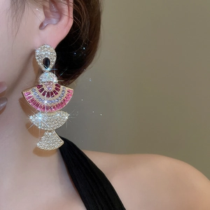 Close-up of a model wearing tiered fan-shaped earrings with pink and clear crystals