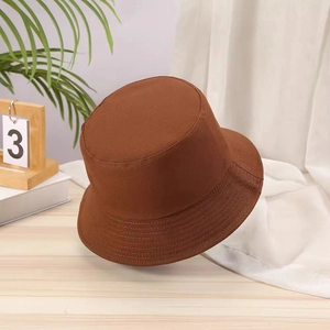 Close-up of a brown cotton bucket hat on a wooden table with soft interior lighting