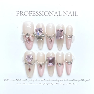 Handmade gradient pink press-on nails with 3D heart gems and pearl chains on white card