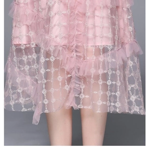 Détail d'une robe en tulle rose avec broderies florales dorées et textures de dentelle