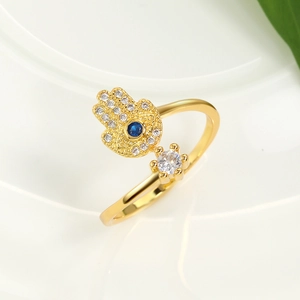 Dettaglio dell'anello mano di Fatima dorato con occhio blu e zirconi scintillanti