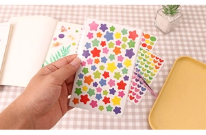 Close-up of colorful star stickers held in hand for DIY journal and album decoration