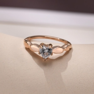 Detail shot of rose gold heart ring with center cubic zirconia and leaf patterns