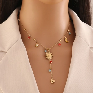 Golden celestial necklace with sun moon and star charms featuring red and blue beads