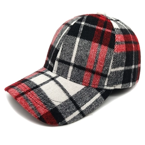 Dettaglio del cappello da baseball a quadri rossi e neri con texture in flanella