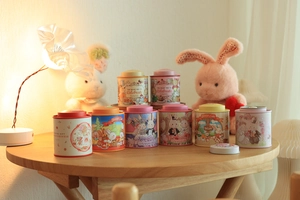 Close-up of decorative rabbit tin jars with festive gold foil detailing and warm colors