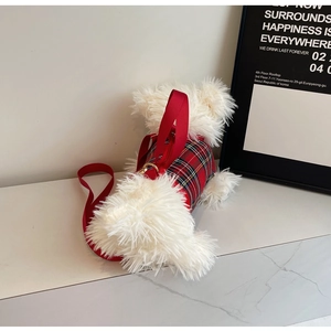 Close-up of white plush dog bag with red plaid vest harness and golden D-ring hardware